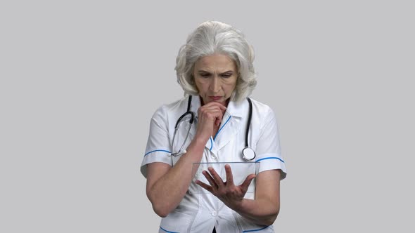 Serious Senior Female Doctor with Glass Mockup Tablet Pc Device alt