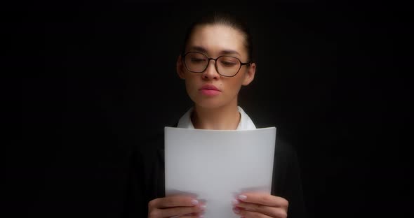 Businesswoman Reads a Document on a White Sheet of Paper Does Not Want to Work