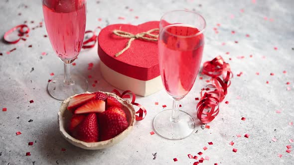 Bottle of Rose Champagne, Glasses with Fresh Strawberries and Heart Shaped Gift alt