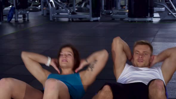 Fitness Man and Woman Train Their Abdominal Muscles alt