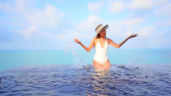 Young asian woman enjoy around outdoor swimming pool for leisure alt