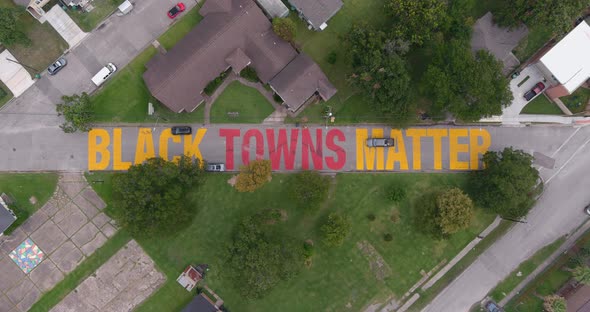 Bird eye view of a large "Black Towns Matter" sign painted on street in Houston Historical independe alt