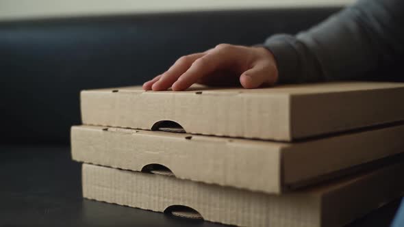 Closeup of Unrecognizable Delivery Man Tapping on Cardboard Pizza Box While Waiting for Customer alt