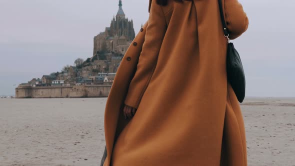 Close-up Fashionable Happy Tourist Woman Slowly Walking on Soft Sea Sand at Epic Mont Saint Michel alt