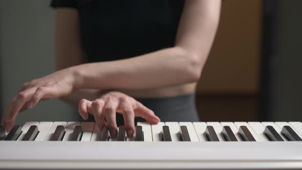 Young Woman Playing on a Piano Closeup