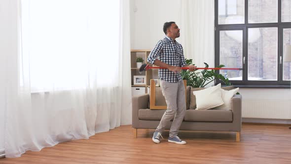 Man with Broom Cleaning and Having Fun at Home alt