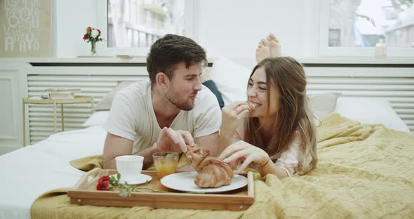 In the Morning a Cute Couple Have Breakfast in Bed alt