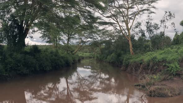 Forwards aerial drone view of river in African landscape in Laikipia, Kenya alt