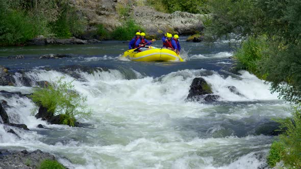 Group of people white water rafting in slow motion