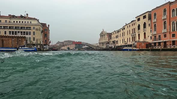 Water surface pov of Venice seen from ferry boat on Canal Grande with Ponte Degli Scalzi bridge in b alt