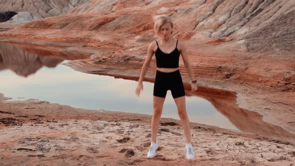 Woman working out on lifeless dried locality