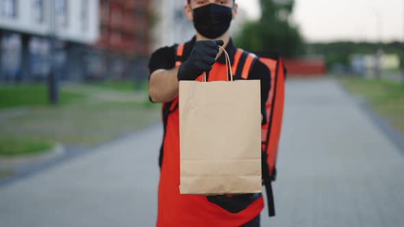 Handsome Courier Man Holding Paper Bag With Food at Street Outdoors Worker Grocery to House Door alt
