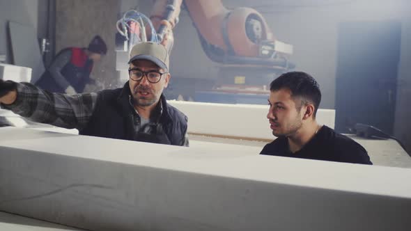 Workers Discussing Plastic Block in Workshop alt