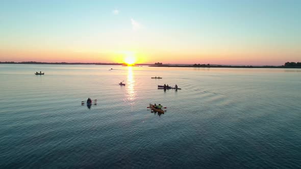 Aerial Drone Footage. A Group of Tourists Are Kayaking. Beautiful Sunrise Over River alt