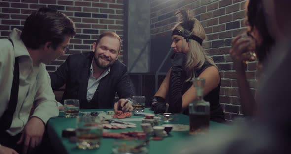 Happy Player Is Looking at a Combination and Cards and Smiling alt