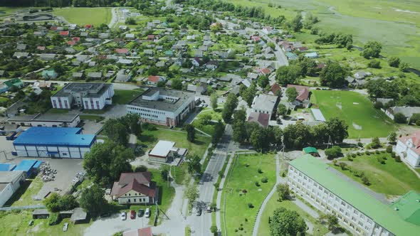 Flight Over A Provincial Town. An Ancient Tower Among The Multi Colored Roofs Of Houses alt