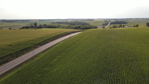 lonely freeway roads in south minnesota next to farms and corn fields during summer time aerial view alt