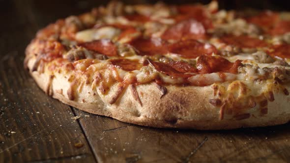 Camera follows a whole pizza with pepperoni being cut. Slow Motion. alt