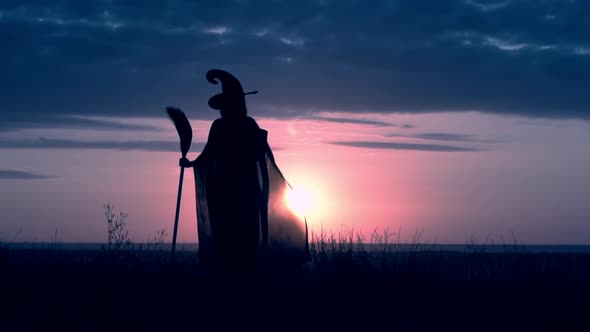 Girl in Fancy Dress Sorceress Conjures with Magic Wand Sunrise View alt