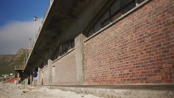African american man running on pavement, exercising outdoors on sunny day alt