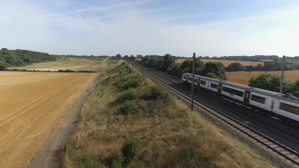 Fast Commuter Train Speeding Through the Countryside During Summer alt