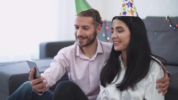 Celebrating Christmas a Young Couple Sits on the Floor of Their New Apartment and Wishes Their alt