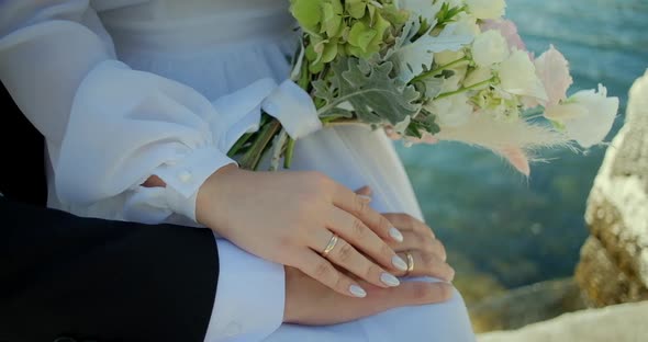 Close up Hands of man and woman with wedding rings, groom and bride standing on ceremony alt