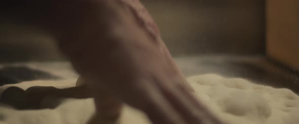 Chef preparing traditional pizza al taglio dough with his hands, slowly kneading dough. alt