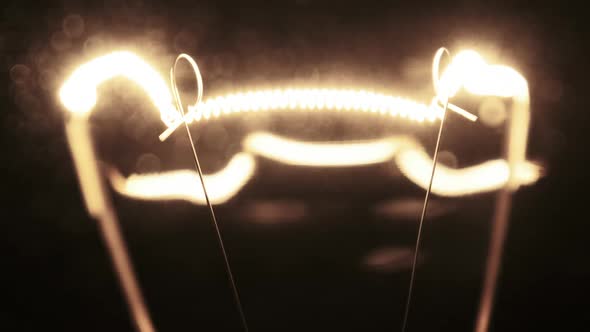 Tungsten Filament in a Glass Lamp Closeup in Slow Motion on Black Background alt