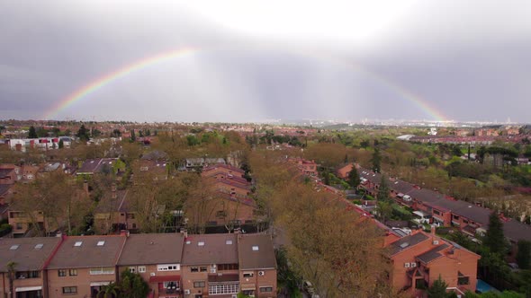 Full rainbow after a stormy day over suburbs in Pozuelo, Madrid, Spain. Fly over alt