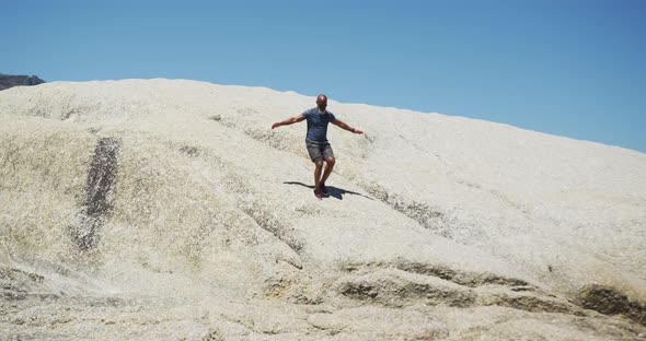 Senior african american man exercising running on rocks by the sea alt
