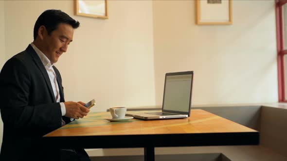 Businessman using mobile phone at table  alt