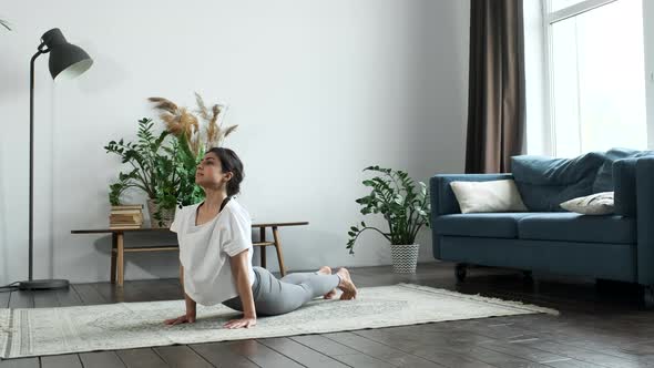 Athletic Healthy Asian woman in sportswear workout yoga cobra pose exercise on yoga at home