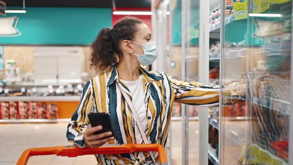 Attractive Brunette Woman Wearing Mask Chooses Seafood in the Supermarket alt