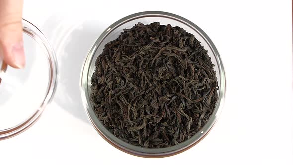 Open Glassy Jar of Tea, Using Spoon, Slow Motion, on White alt