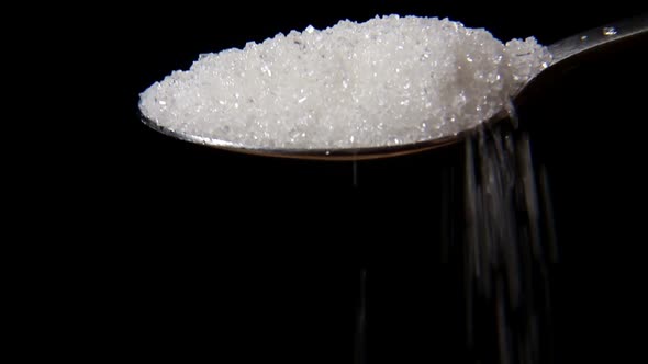 Closeup Macro of Pouring Full Spoon Crystals White Sugar . alt