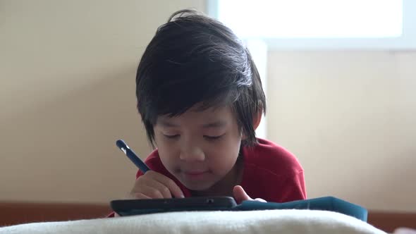 Asian Child Drawing Picture With Digital Pen On Tablet Pc Computer alt