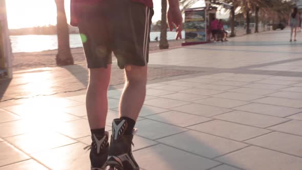 Slow motion,  on person's legs roller blading on pavement during golden hour. No face alt