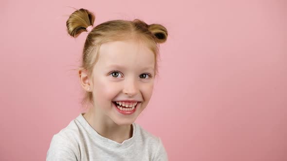 Funny Little Blonde Girl Smiling and Lughing on Pink Background alt