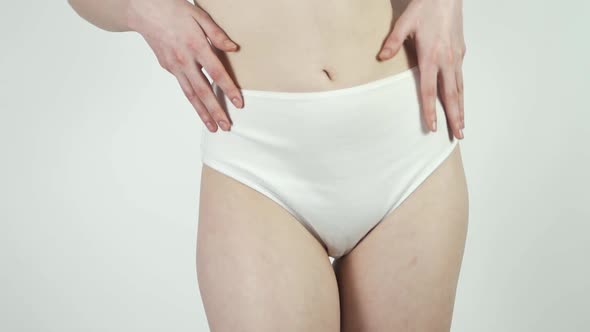 A Woman in White Underwear Moves and Dances Gently on a White Background