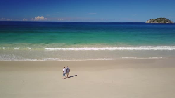 Drone View Couple Walking Along Beach