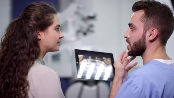 Doctor Showing Jaw X-Ray to Female Patient alt