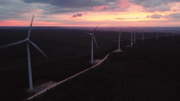 Wind Turbine Farm on Beautiful Purple Evening Mountain Landscape. Renewable Energy Production for alt