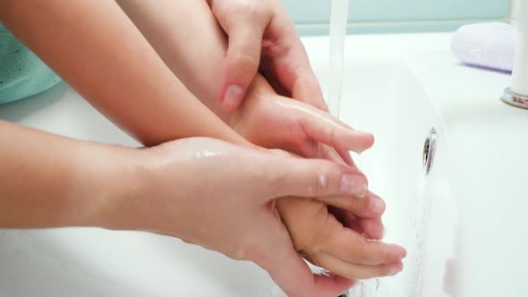 Closeup of Mother Washing Hands To Her Little Toddler Son alt