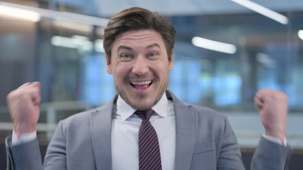Portrait of Middle Aged Businessman Celebrating Success alt