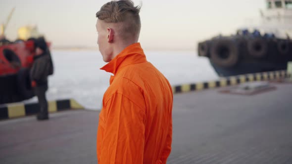 Dock Worker in Orange Uniform Walking in the Harbor and Controlling Working Process in the Port alt
