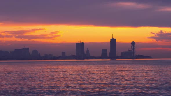 Sea and sunset on the background of resort town. Batumi in Georgia. alt