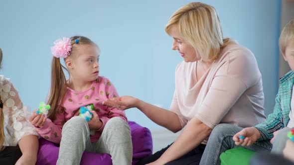 Woman Teacher Conducts Training Sessions in Inclusive Classroom and Establishes Contact with Girl alt