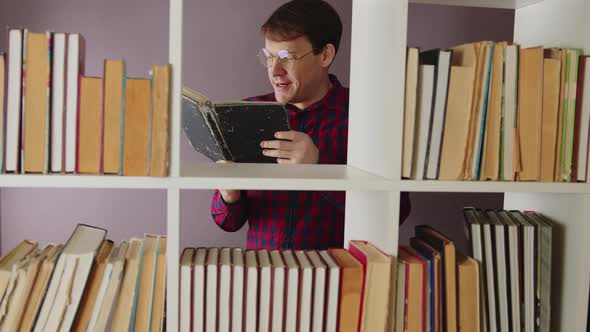 Man Reading Book Near Bookcase and Starting Dancing alt