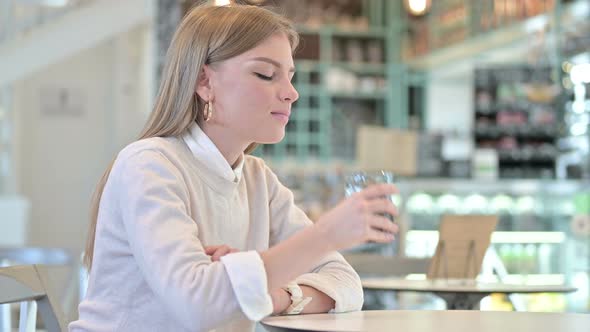 Healthy Young Woman Drinking Water in Cafe alt